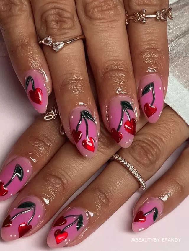 Cute pink cherry-themed nails with glossy red heart cherries and whimsical details.