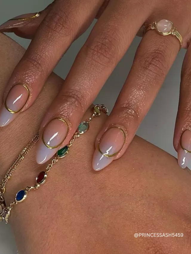 Almond nude nails with delicate gold outline detailing.