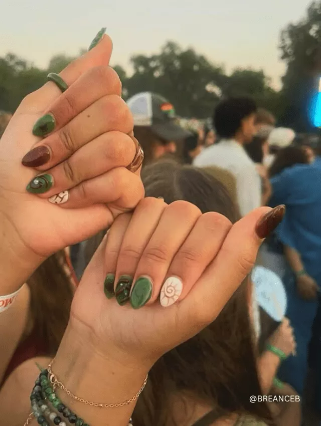 Earth-toned nail design featuring marbled green, deep burgundy, and nature-inspired patterns.