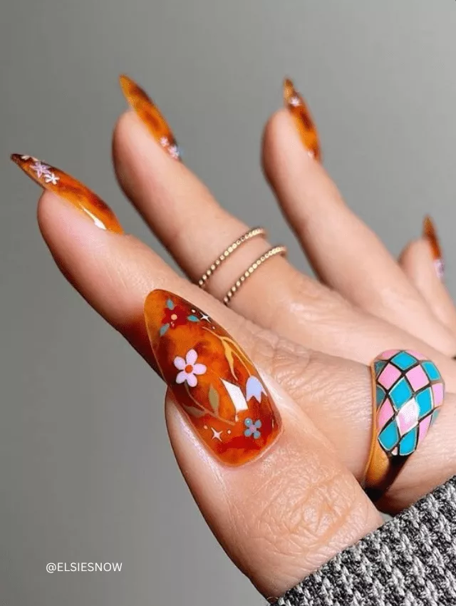 Amber-colored marble nails with tiny floral details.