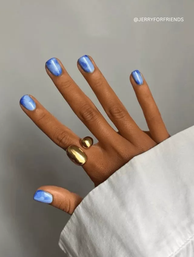 Sleek metallic blue chrome nails with a cat-eye effect and high-shine finish.