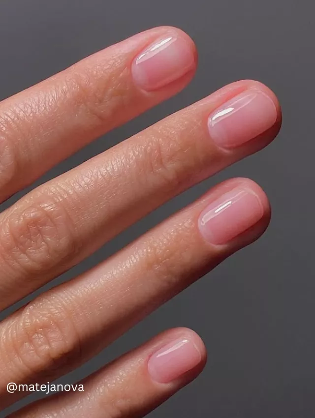  A close-up image of a hand displaying sheer elegance nails with a natural pink gradient finish.