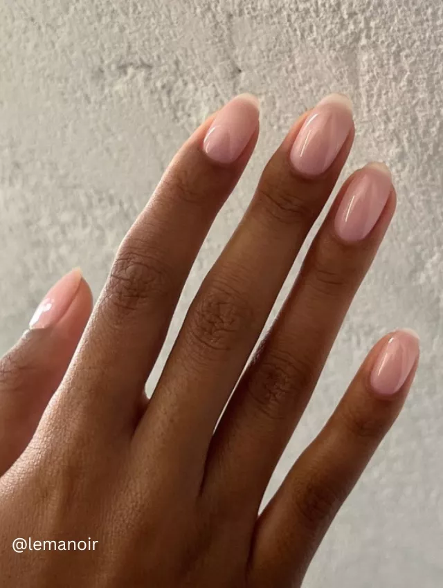 Image of a hand showing long almond-shaped nails painted in a soft blush pink.