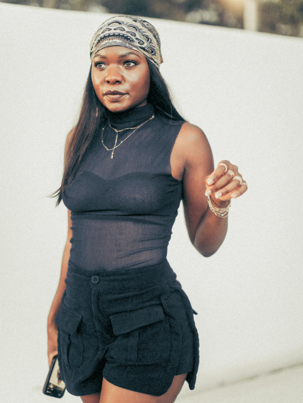 ropa de playa para esta Semana Santa, mujer con top negro y shorts cargo, con pañuelo en la cabeza y accesorios, inspiración de ropa de playa para un look moderno.