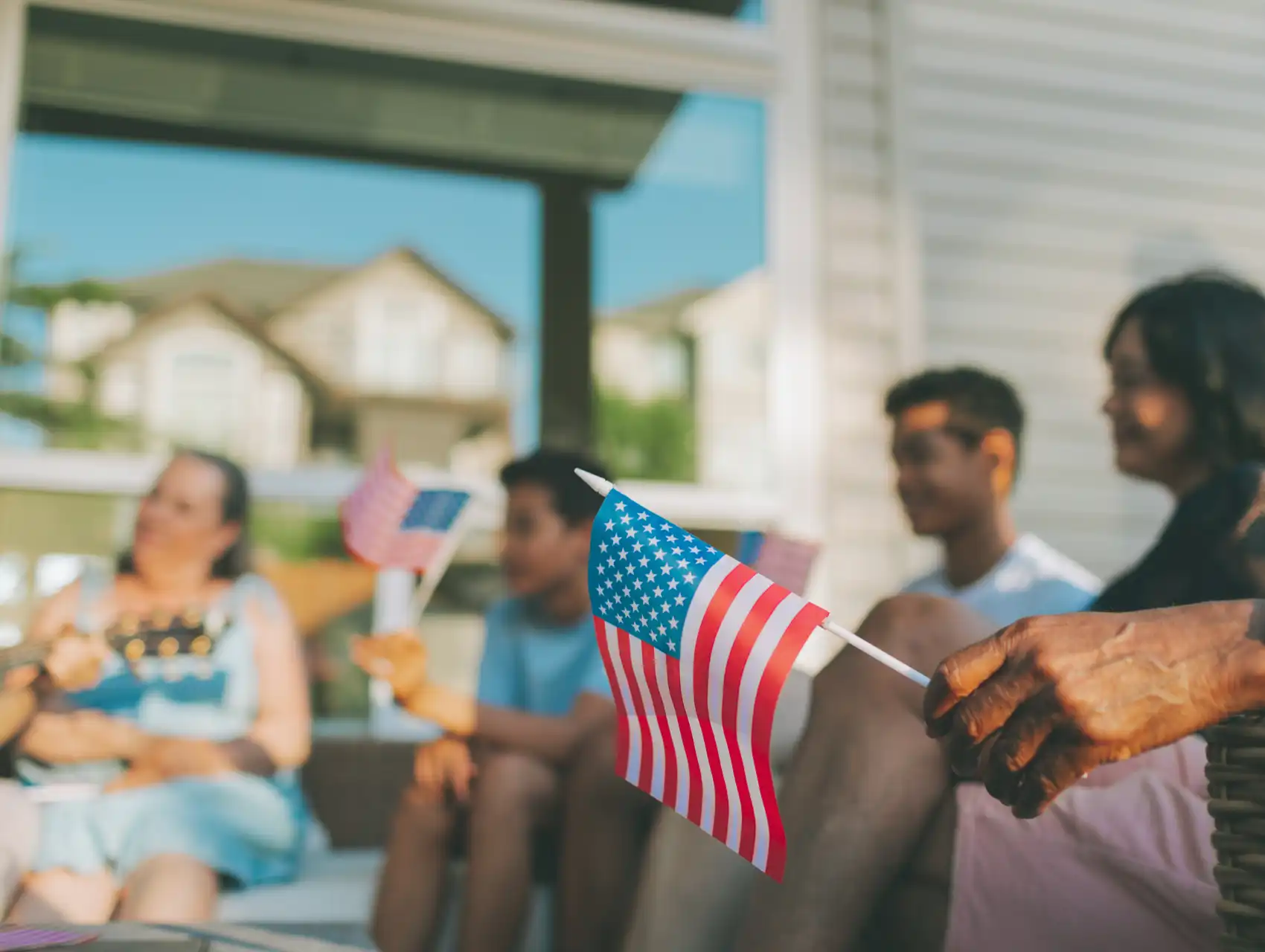 Family celebrating 4th of July on front porch in Orlando with American flags