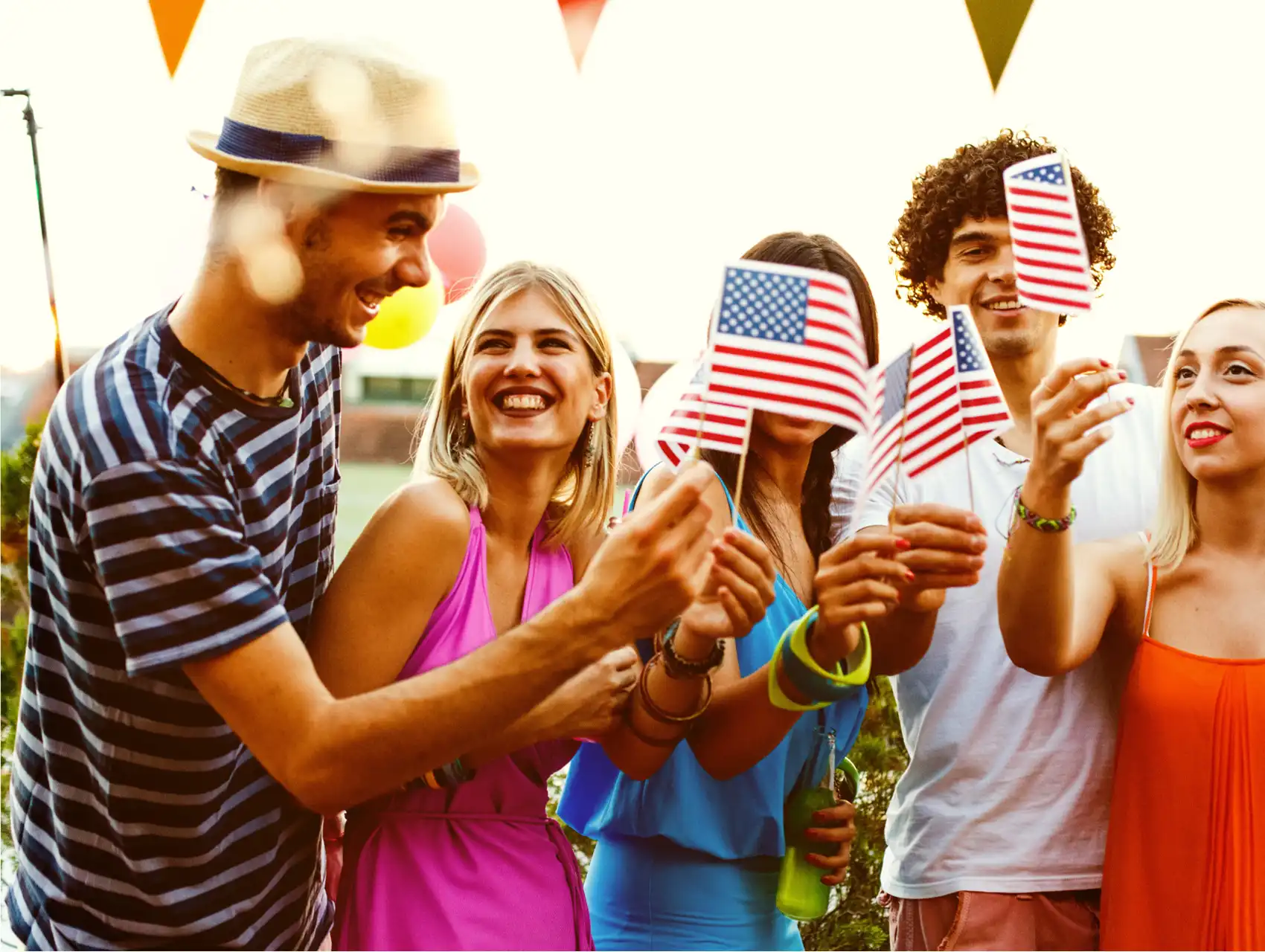 Group of young adults celebrating 4th of July in Orlando with American flags and summer outfits