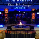 A lively nighttime scene with glowing lights, outdoor seating, and a cozy fire pit, capturing the vibrant atmosphere of Orlando nightclubs near Disney.