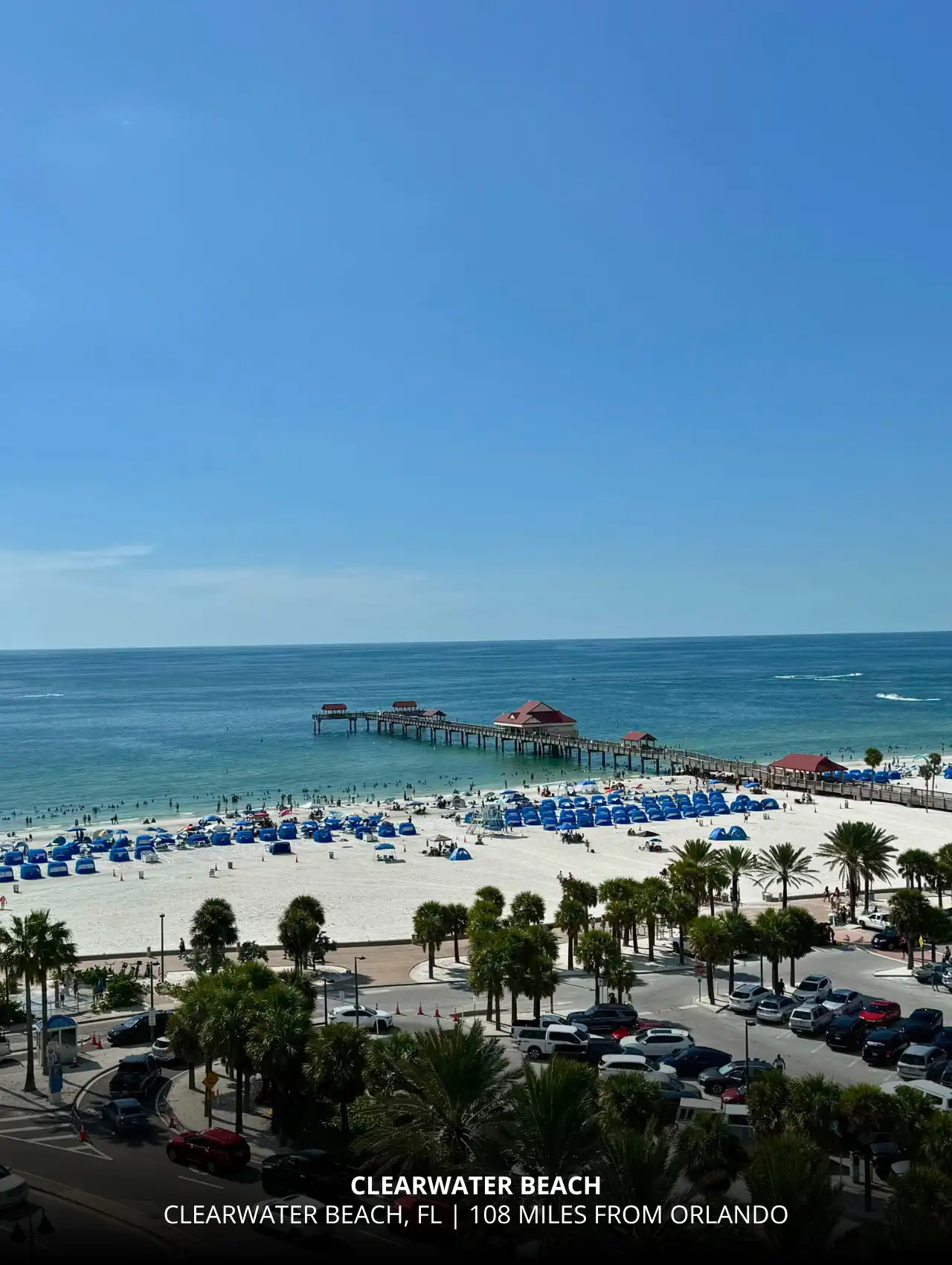 View of Clearwater Beach with white sand and blue umbrellas, one of the closest Gulf beaches to Orlando.