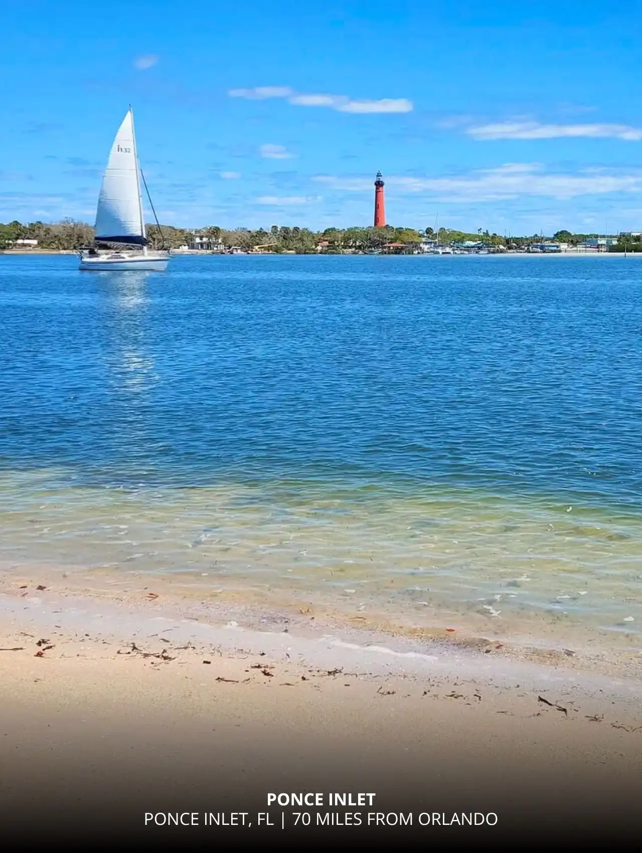 Sailboat passing by the red lighthouse at Ponce Inlet, a charming closest beach to Orlando.