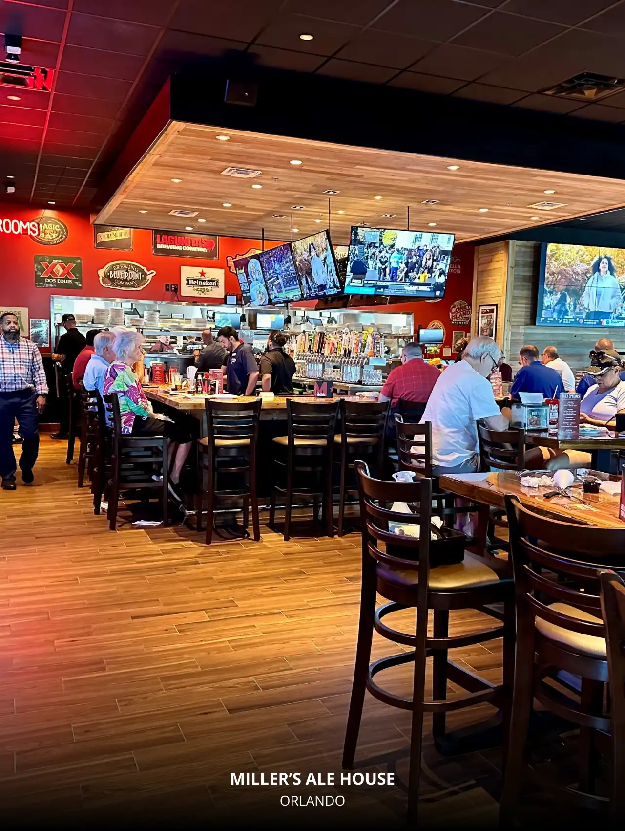 Lively bar area at Miller’s Ale House with multiple TVs, Orlando Sports Bars