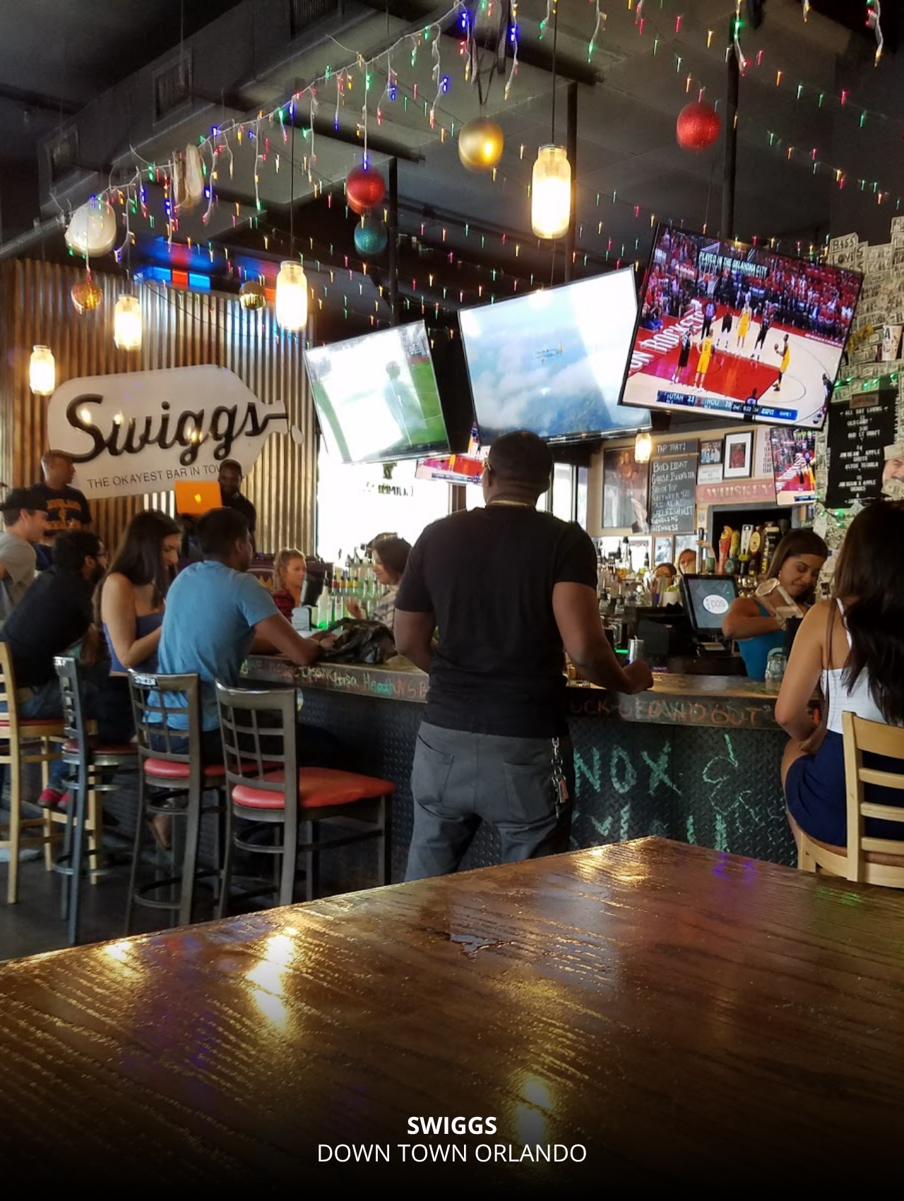 Festive crowd enjoying drinks and sports at Swiggs, Orlando Sports Bars