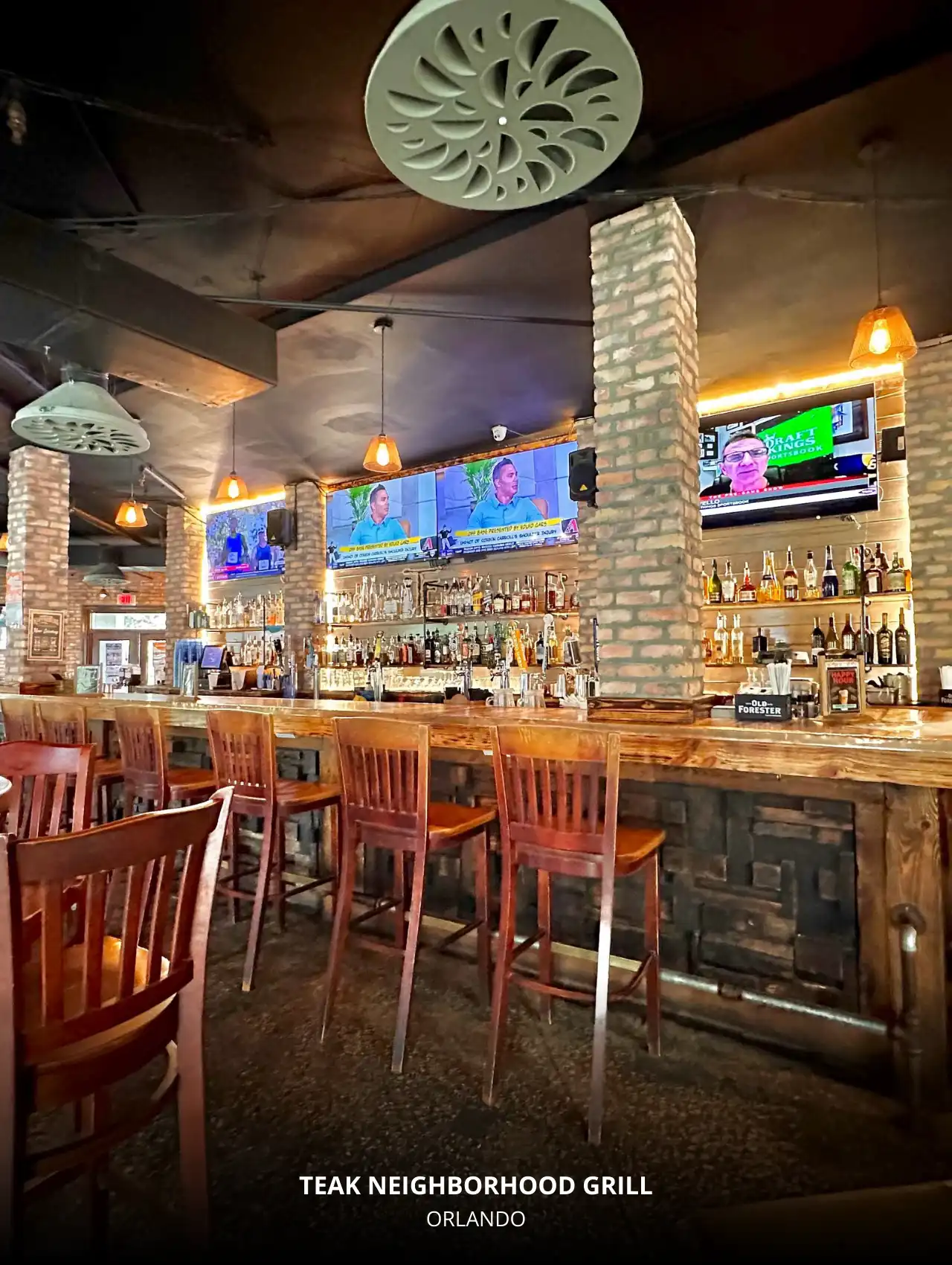 Brick-lined bar at Teak Neighborhood Grill with multiple sports screens, Orlando Sports Bars