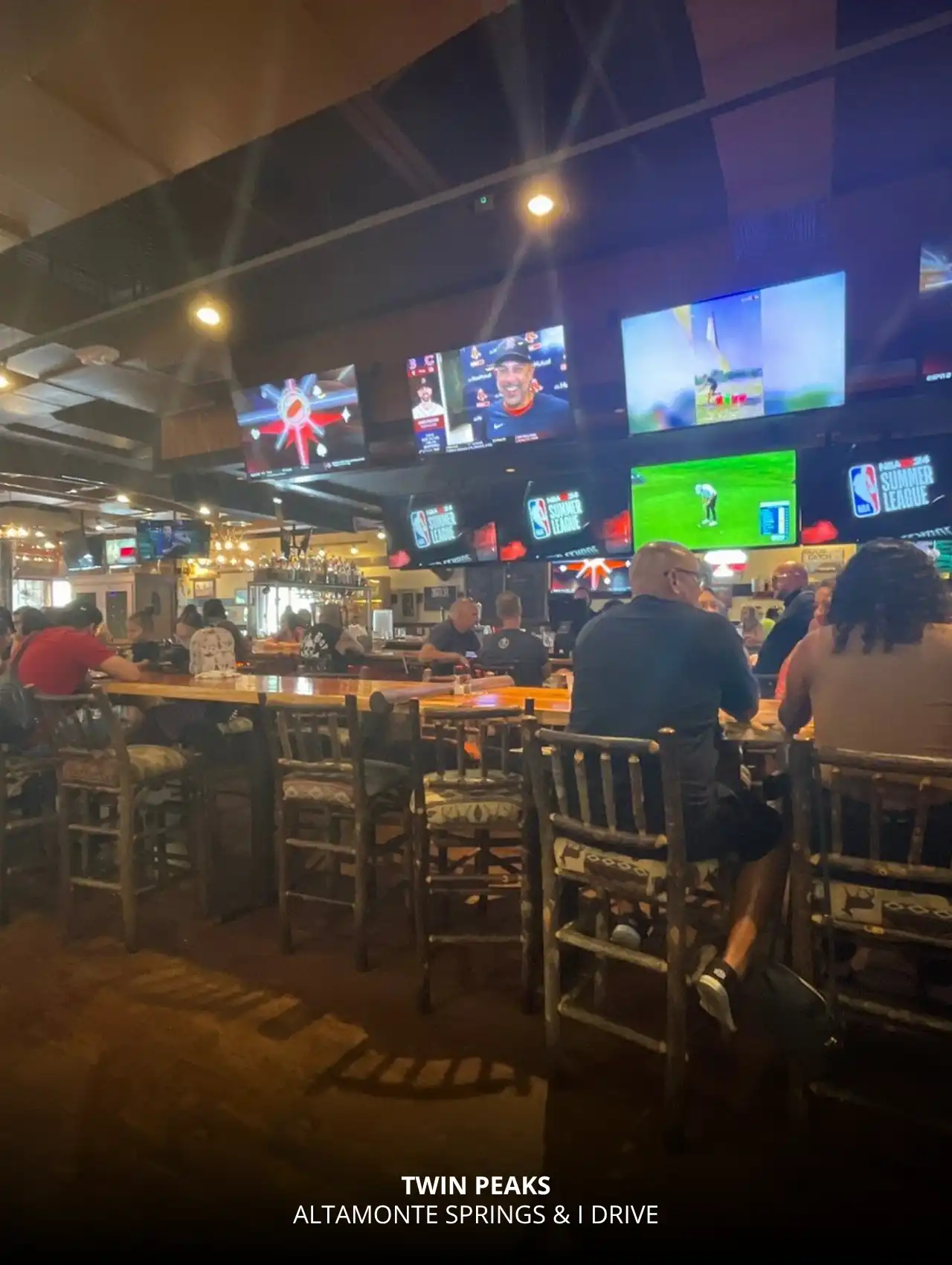 Warm, cabin-style interior with sports on multiple TVs at Twin Peaks, Orlando Sports Bars