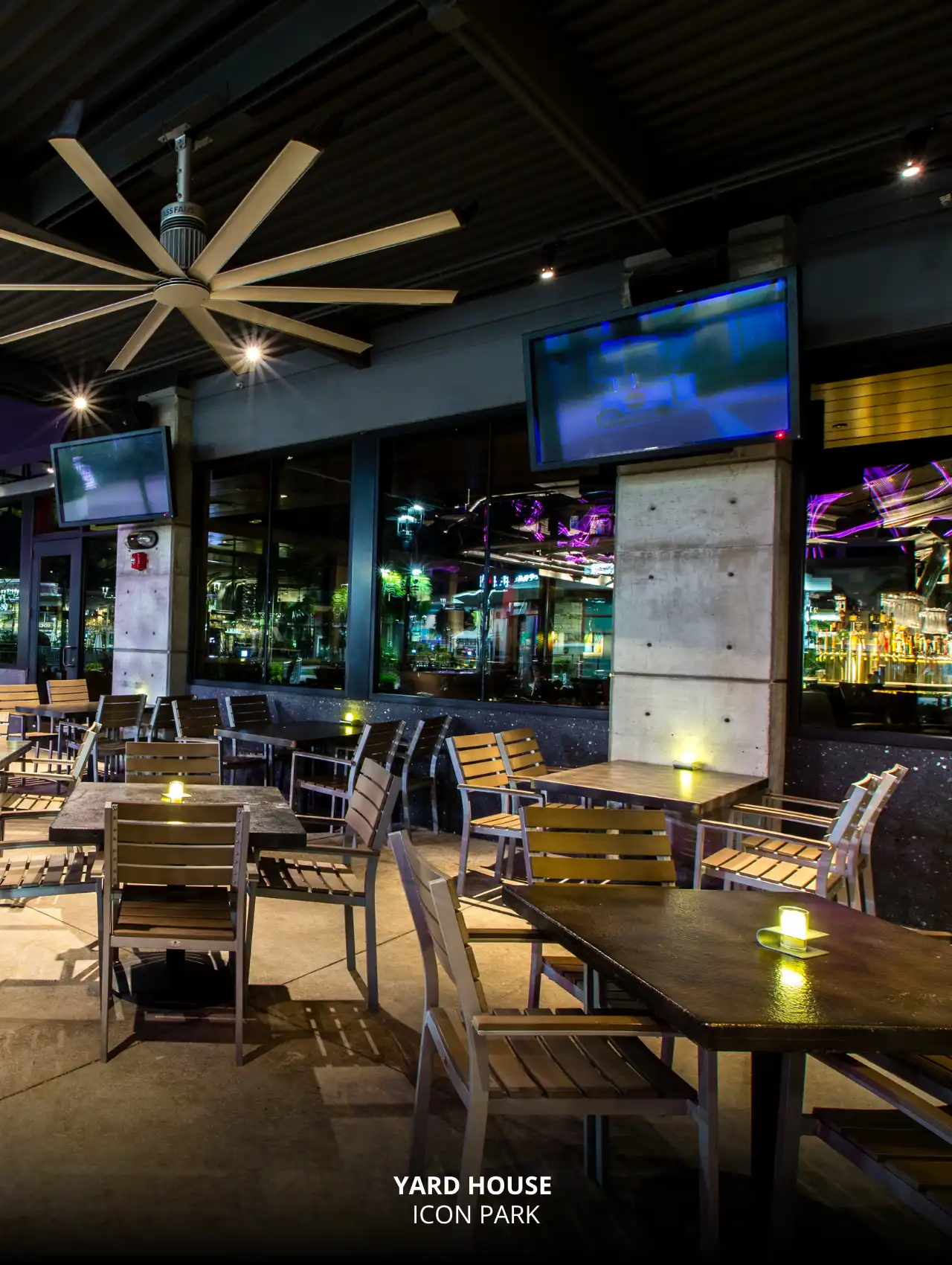 Outdoor seating with mounted TVs at Yard House in ICON Park, Orlando Sports Bars