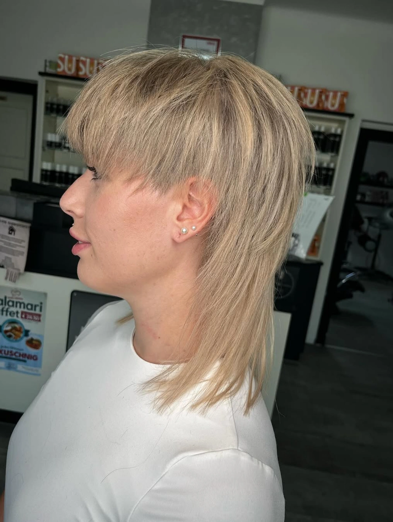 Blonde mullet haircut with sleek layers, modern mullet hairstyle.