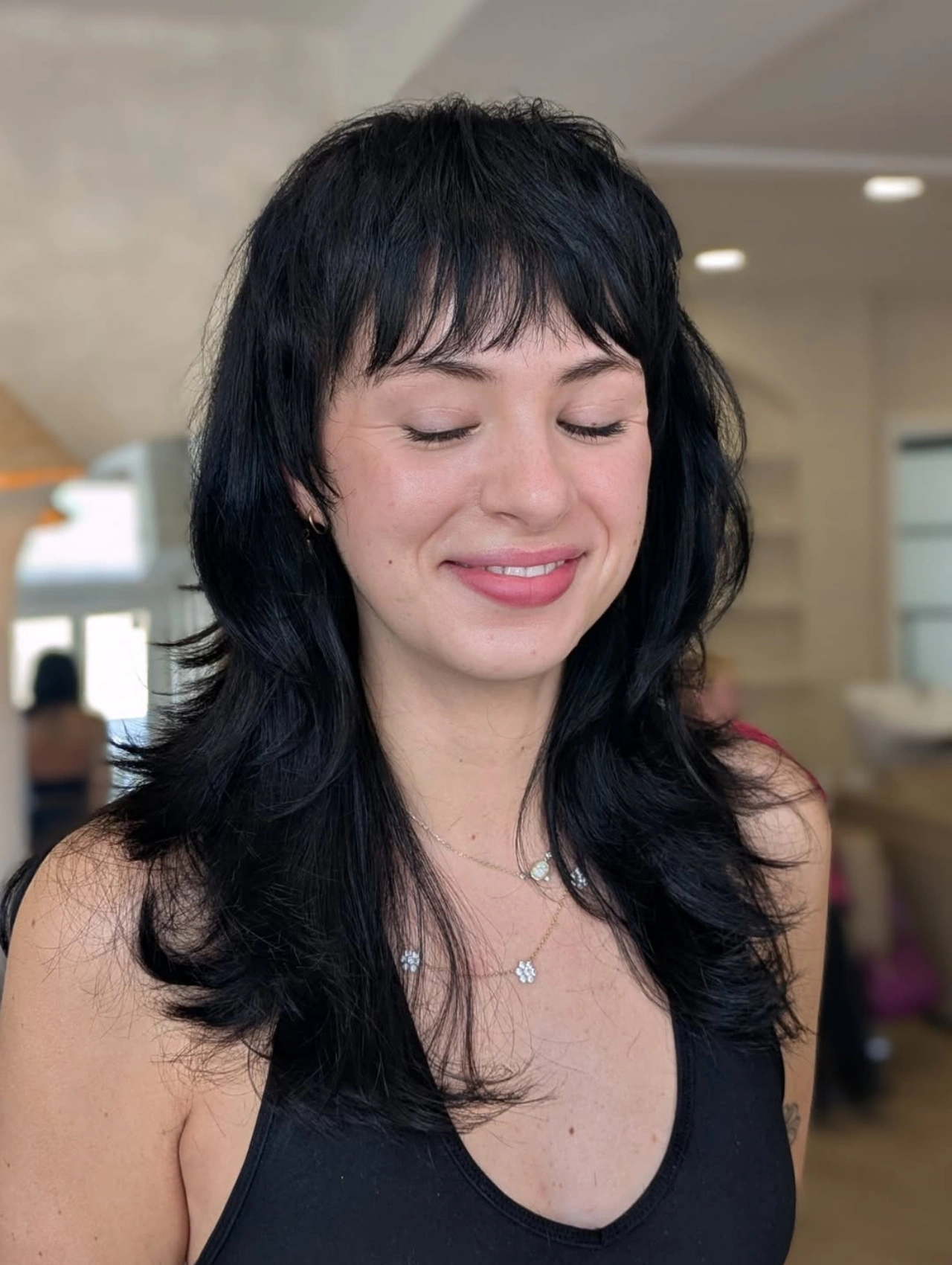 Long mullet haircut with layered bangs, modern hairstyle.