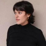 Woman with a modern mullet haircut for girls, showcasing short layers and textured ends.