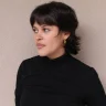 Woman with a modern mullet haircut for girls, showcasing short layers and textured ends.