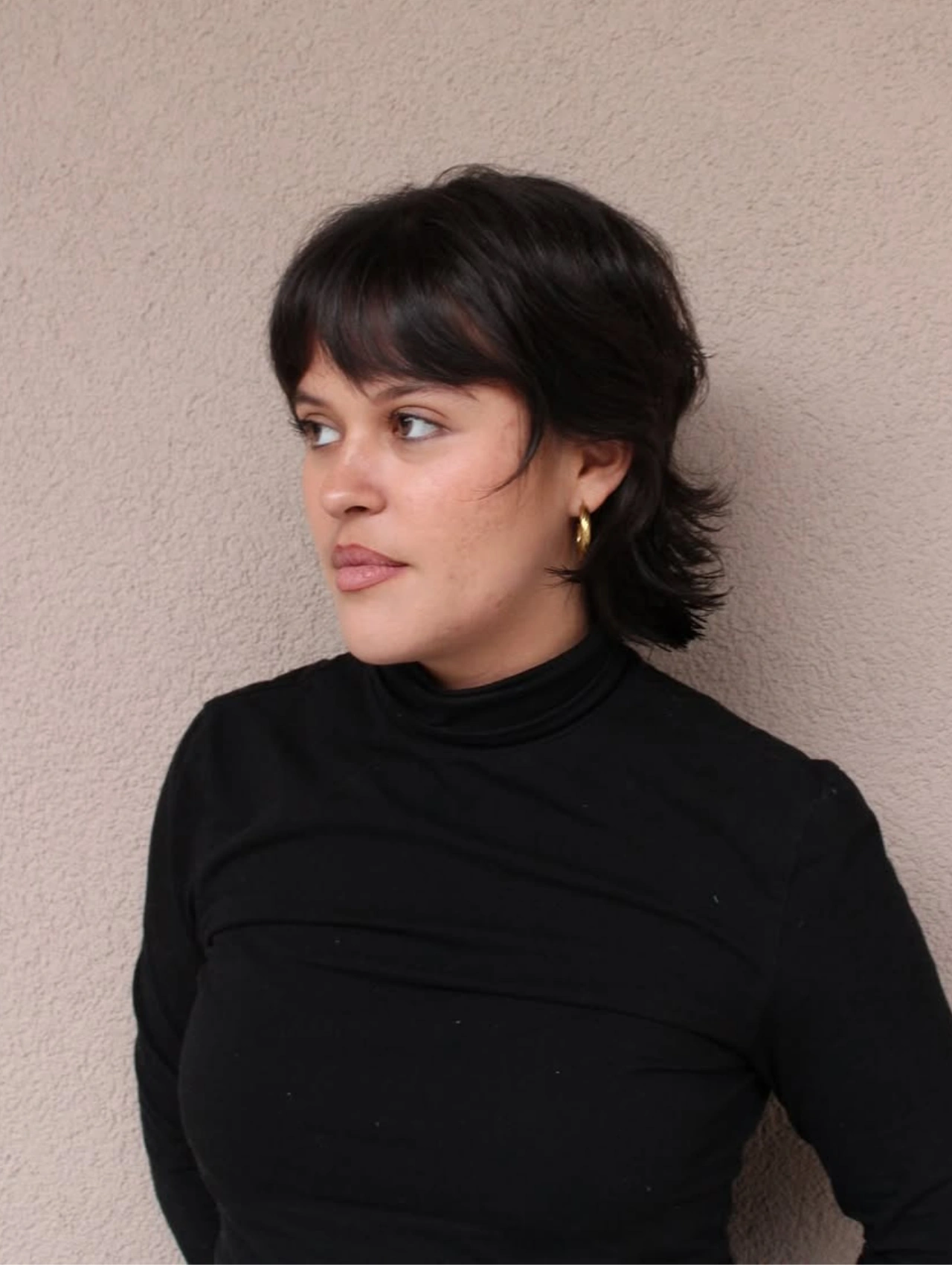 Woman with a modern mullet haircut for girls, showcasing short layers and textured ends.
