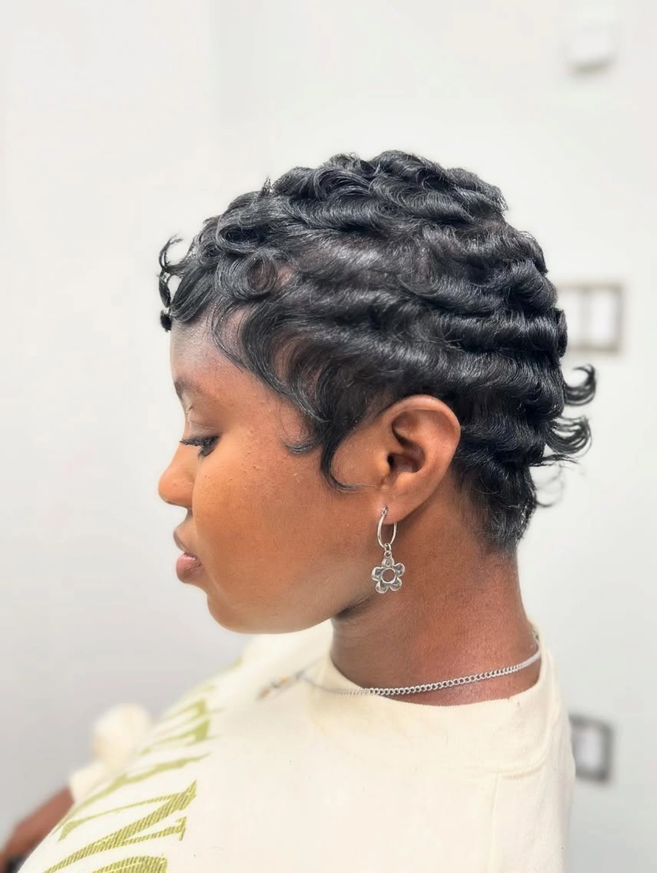 Woman with Finger Waves Pixie Cut Hairstyle, sleek sculpted curls close to the scalp.