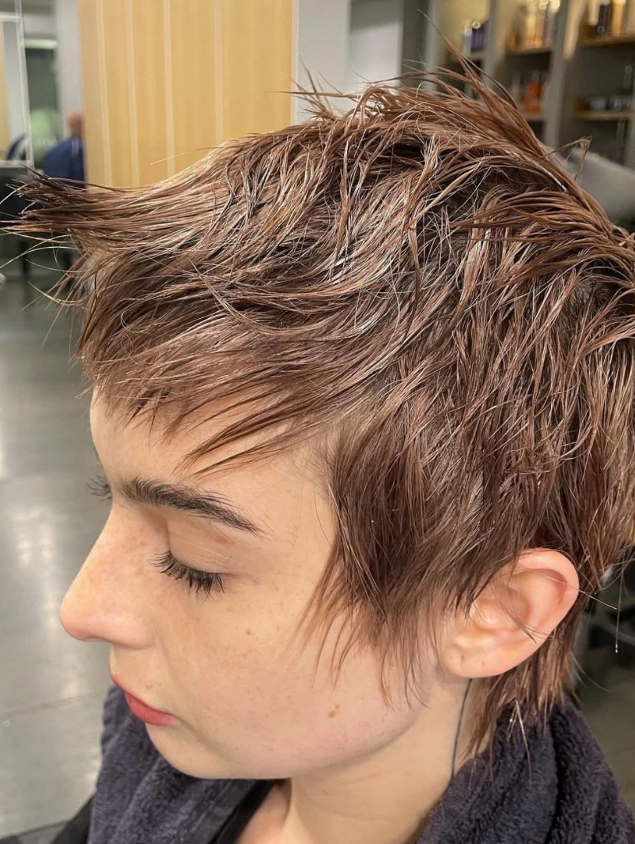 Woman with Wet Textured Pixie Cut Hairstyle, tousled short layers.