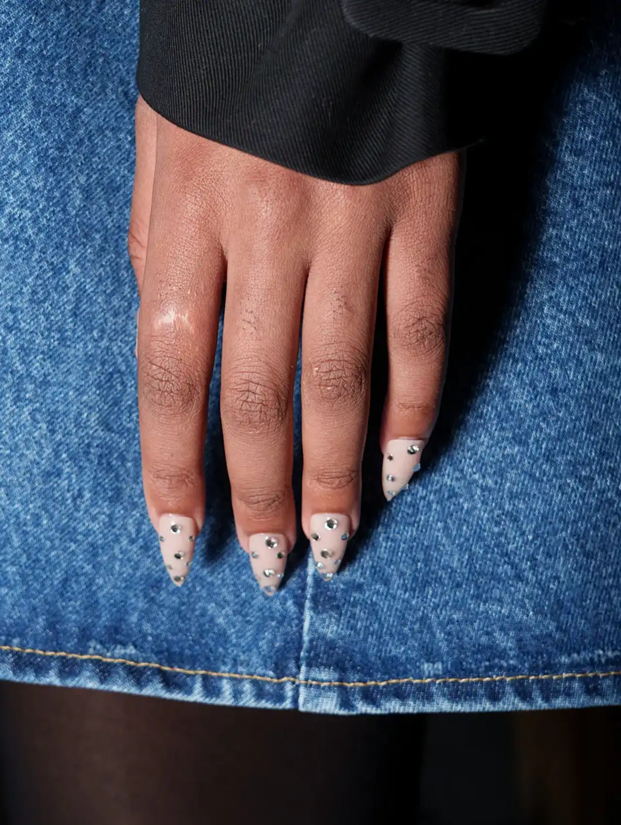 Uñas de Tendencia con base nude y aplicaciones de pedrería plateada