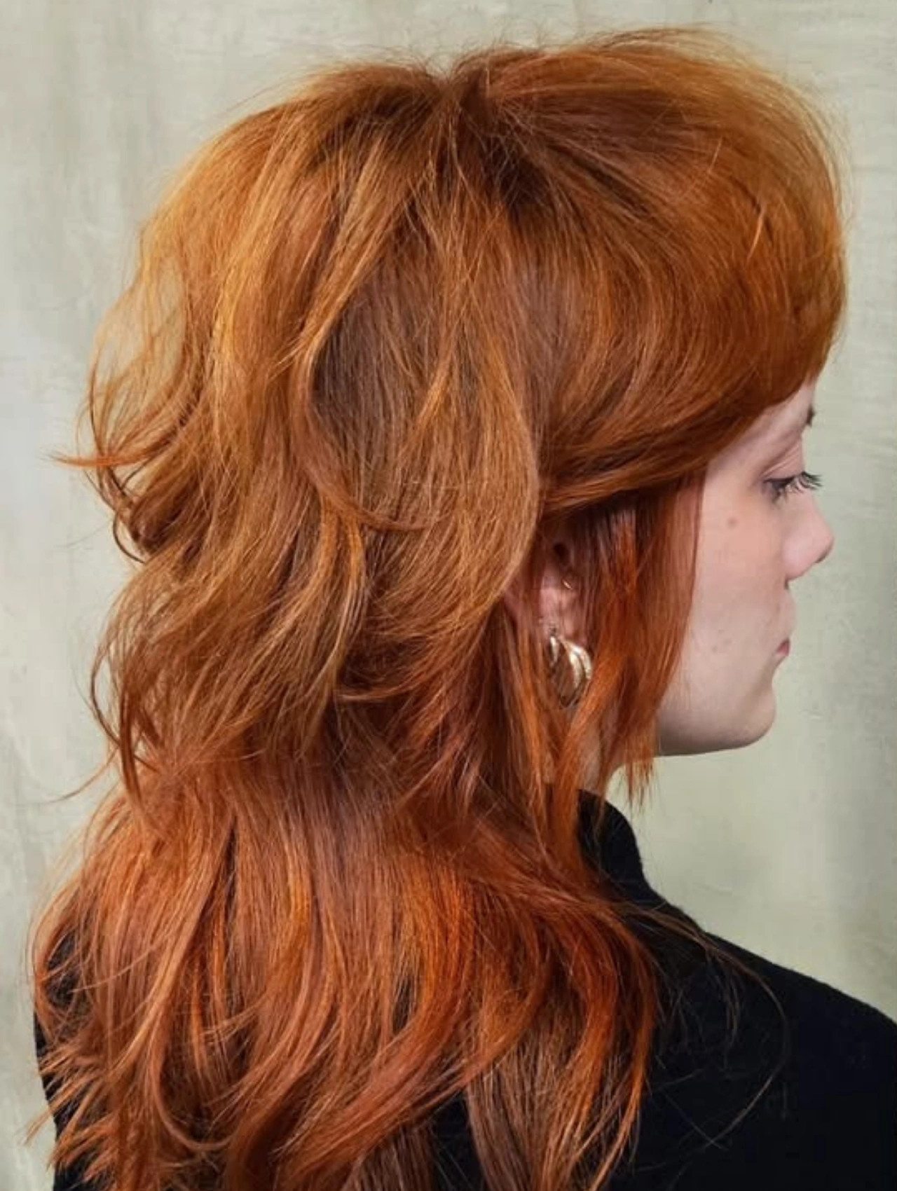 Red mullet haircut with voluminous layers and bold style, modern mullet hairstyle.
