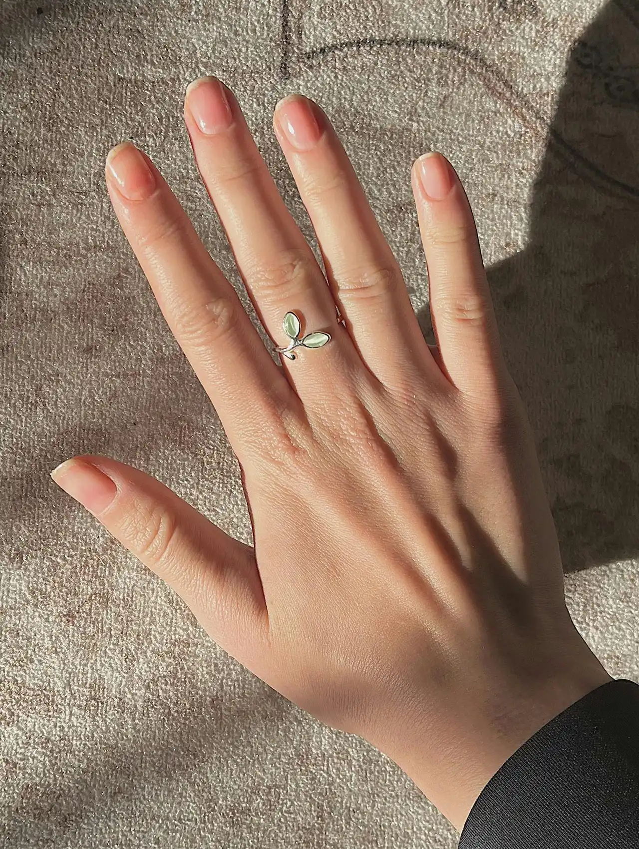 Close-up of a hand with natural nails finished with a clear topcoat nail polish.