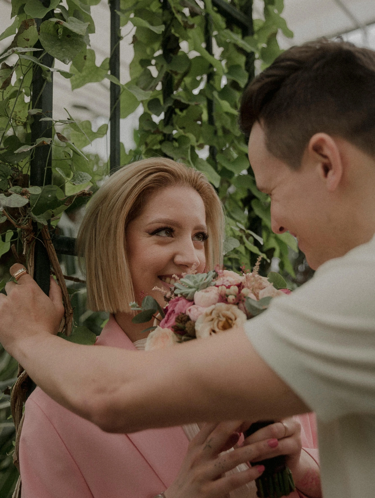Pareja sonriendo con flores, representando qué significa realmente atraer a una mujer.