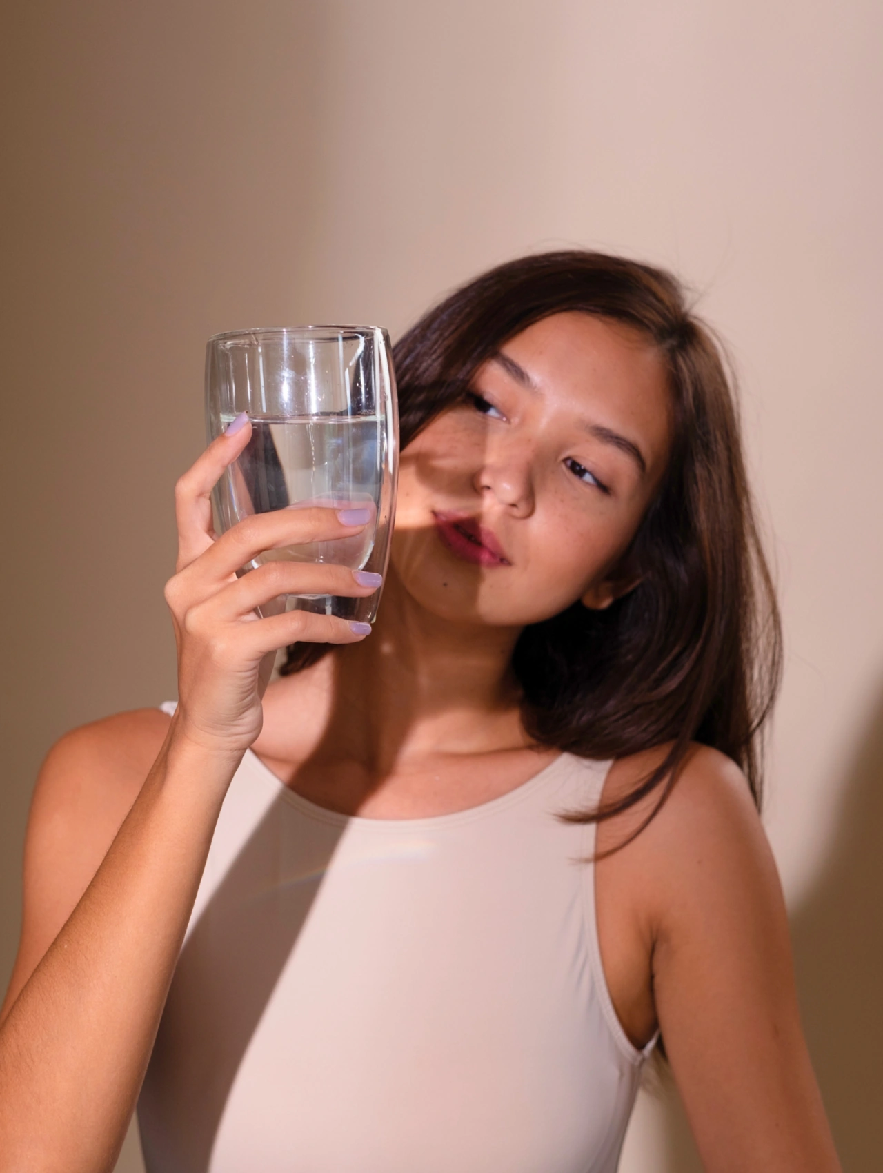 Gut-Friendly Ways to Support Beauty From Within image showing a woman holding a glass of water, representing Gut Balance and inner wellness.