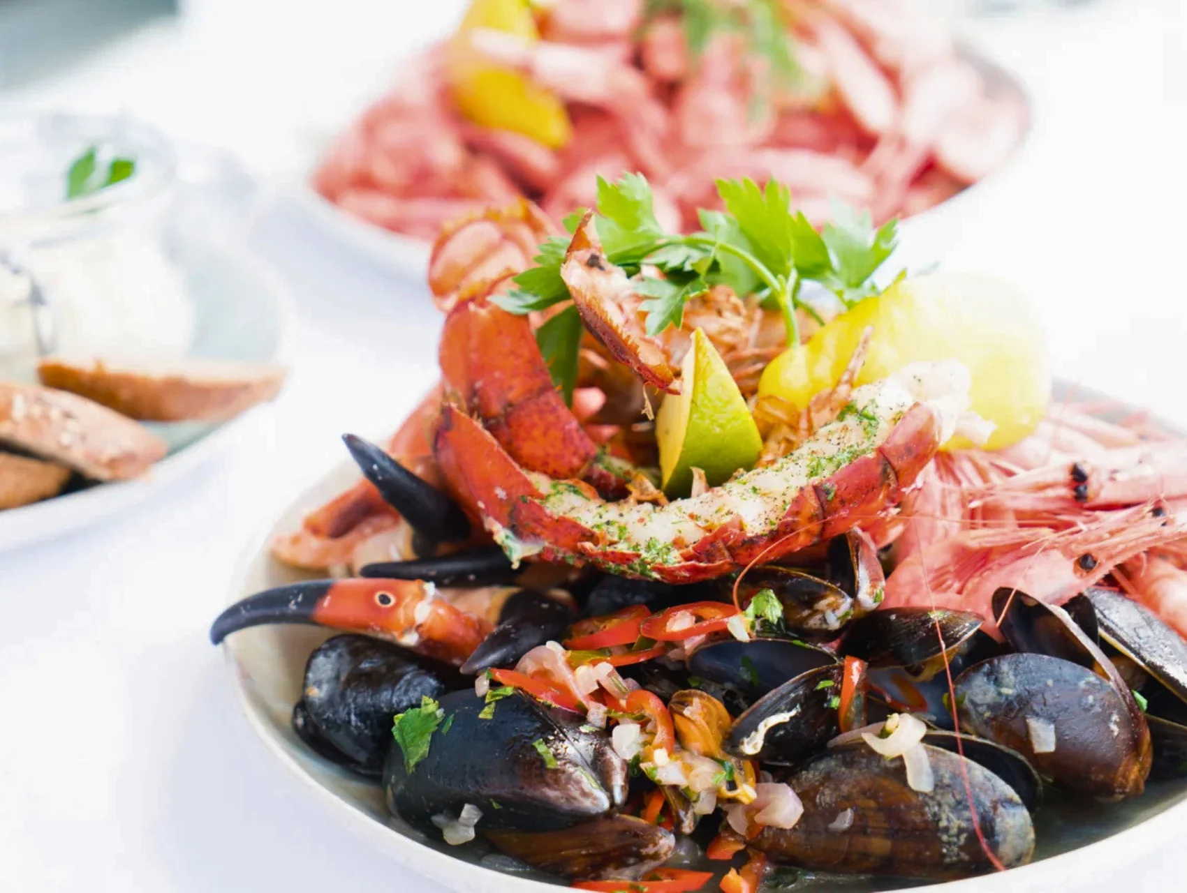 Lobster, mussels and prawns plated with lemon and fresh herbs, a delicious gourmet meal served at a bright table